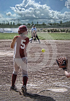 Back view of softball player after swinging bat