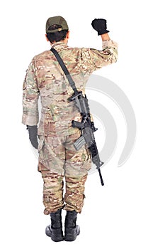 Back view of a soldier with gun holding his arm up