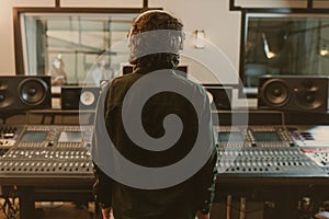back view of sound producer in headphones