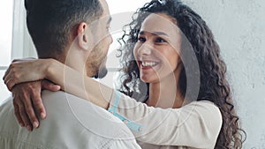 Back view spaniard man husband boyfriend hugs curly brunette woman spanish wife, happy ethnic couple in love at home