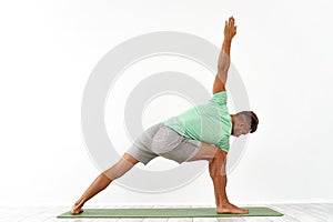 back view of sporty man practicing yoga in yoga class, making stretching back. Healthy lifestyle, Yoga Practice Exercise