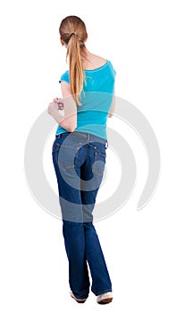Back view of standing young beautiful blonde woman
