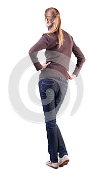 Back view of standing young beautiful blonde woman