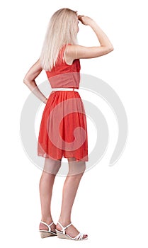 Back view of standing young beautiful blonde woman.