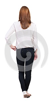 Back view of standing young beautiful blonde woman in jeans.