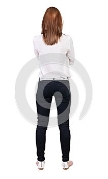 Back view of standing young beautiful blonde woman in jeans.