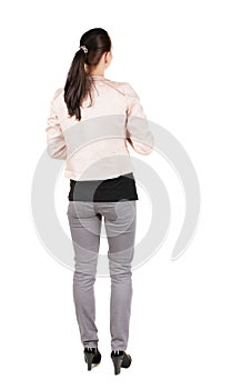 Back view of standing young beautiful brunette woman.