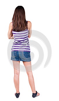 Back view of standing young beautiful brunette woman