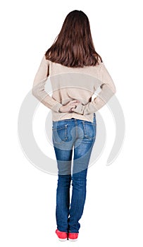 Back view of standing young beautiful brunette woman.