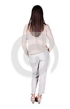 Back view of standing young beautiful brunette woman.