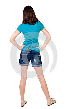 Back view of standing young beautiful brunette woman in shorts.