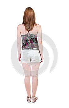 Back view of standing young beautiful brunette woman in shorts.