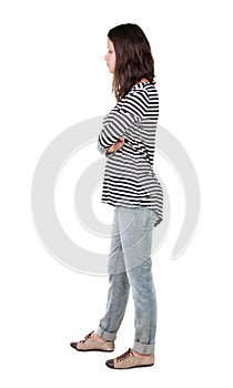 Back view of standing young beautiful brunette woman in striped