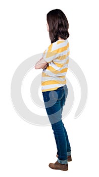 Back view of standing young beautiful brunette woman in yellow