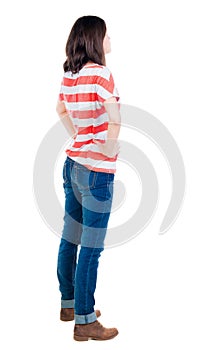 Back view of standing young beautiful brunette woman in yellow