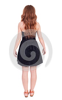 Back view of standing young beautiful redhead woman
