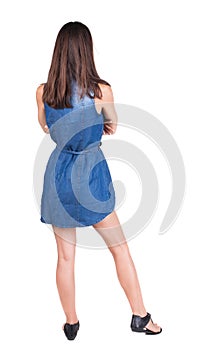 Back view of standing young beautiful woman.