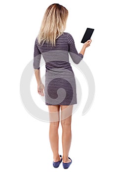 Back view of standing young beautiful woman using a mobile phon