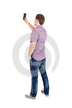 Back view of standing young men and using a mobile phone.