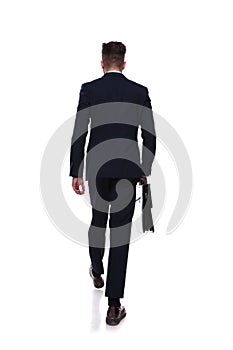 Back view of stepping businessman with briefcase in hand