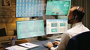 Back view of stock market trader looking at graphs
