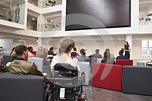 Back view of students at a lecture in a university atrium