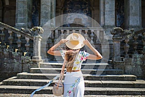 Back view of a stylish female tourist admires of a beautiful architectural building during walking in foreign city, young woman tr