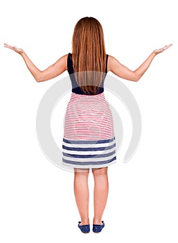 Back view of surprised beautiful redhead young woman with hands