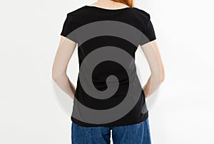 Back view t-shirt design, happy people concept - smiling red hair woman in blank black t-shirt pointing her fingers at herself,