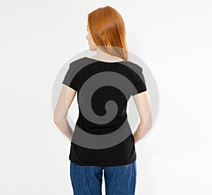Back view t-shirt design, happy people concept - smiling red hair woman in blank black t-shirt pointing her fingers at herself,