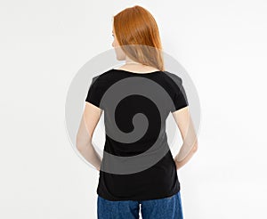 Back view t-shirt design, happy people concept - smiling red hair woman in blank black t-shirt pointing her fingers at herself,