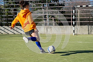 Back view of teenage girl enjoying playing football