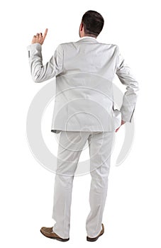 Back view of thinking young business man in white suit.