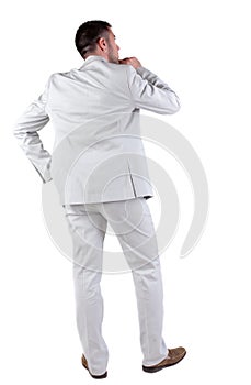 Back view of thinking young business man in white suit.