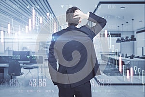 Back view of thoughtful young european man standing on blurry office interior background with creative glowing big data forex