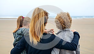 Back view of three generations female looking at sea