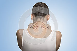 Back view tired female massaging her painful neck photo