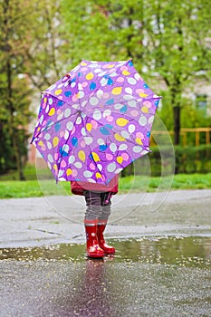 Back view of toddler girl with umbrella