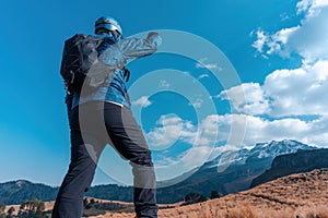 A back view of a tourist with a backpack and the Iztaccihuatl volcanic mountain in the background photo