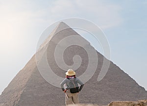 back view of tourist woman standing in front of a pyramid. Egypt, Cairo - Giza photo