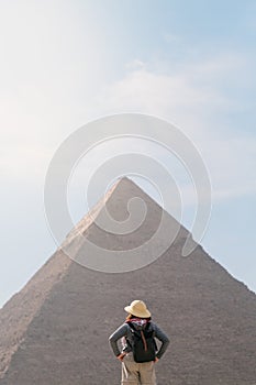 back view of tourist woman standing in front of a pyramid. Egypt, Cairo - Giza