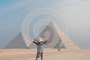 back view of tourist woman standing in front of pyramids. Egypt, Cairo - Giza photo