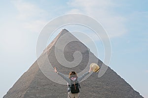 back view of tourist woman standing in front of a pyramid. Egypt, Cairo - Giza photo