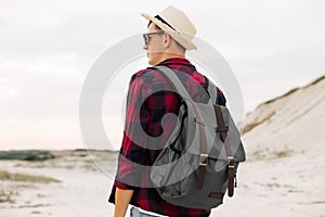 Back view, traveler man , raising his hands up on the trail on the top of the mountain, Tourist on top of high rocks