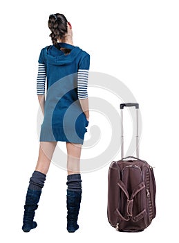 Back view of traveling brunette woman with suitcase