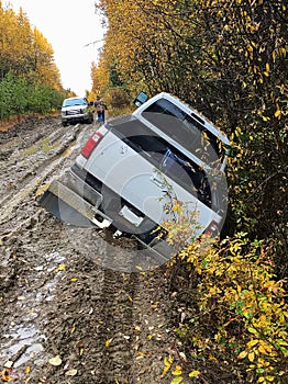 Back view of a truck that has driven off the edge of a muddy road