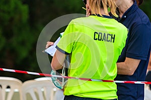 Back view of two female sport swimming coaches discussing about photo