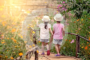 Back view of two little girls holding hand and walking together