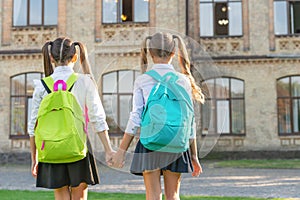 back view of two schoolkids with school backpack walking together outdoor. copy space