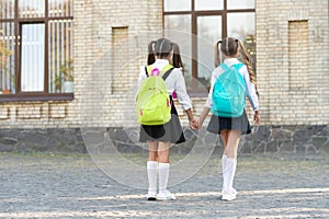 back view of two students with school backpack walking together outdoor